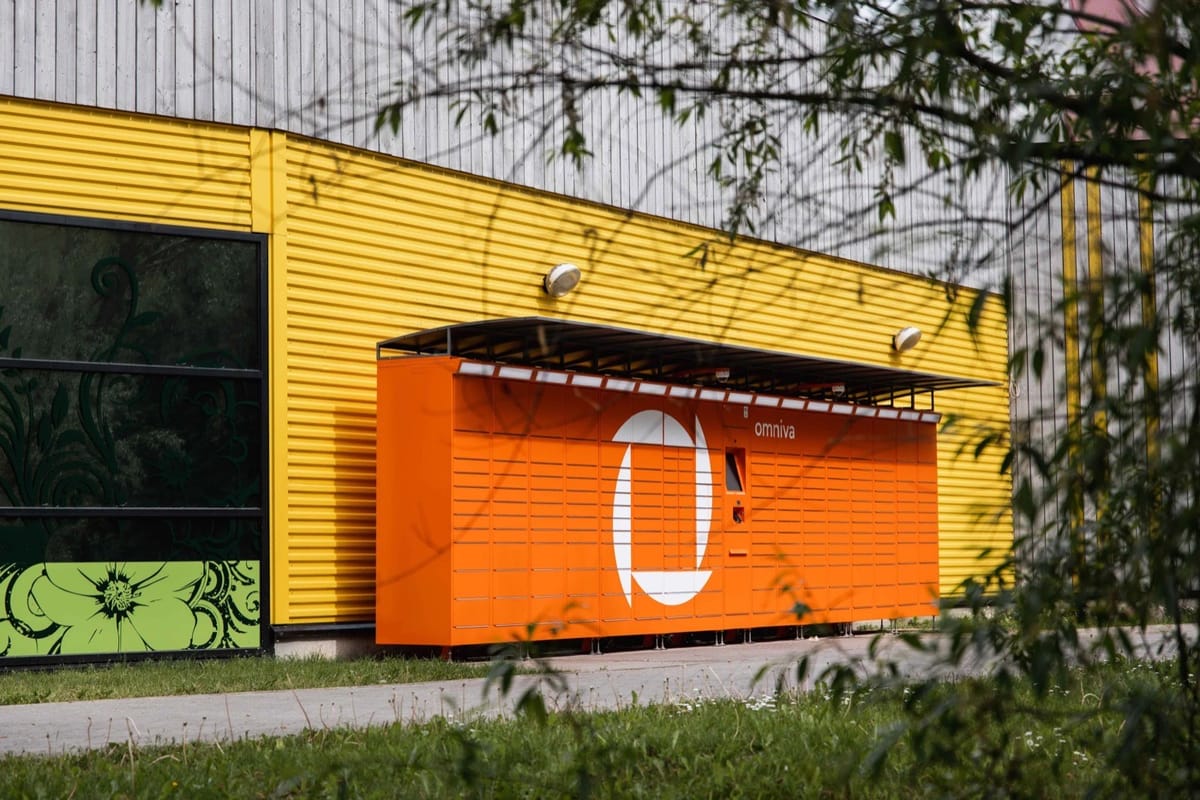 An Omniva parcel machine along the wall of a business building